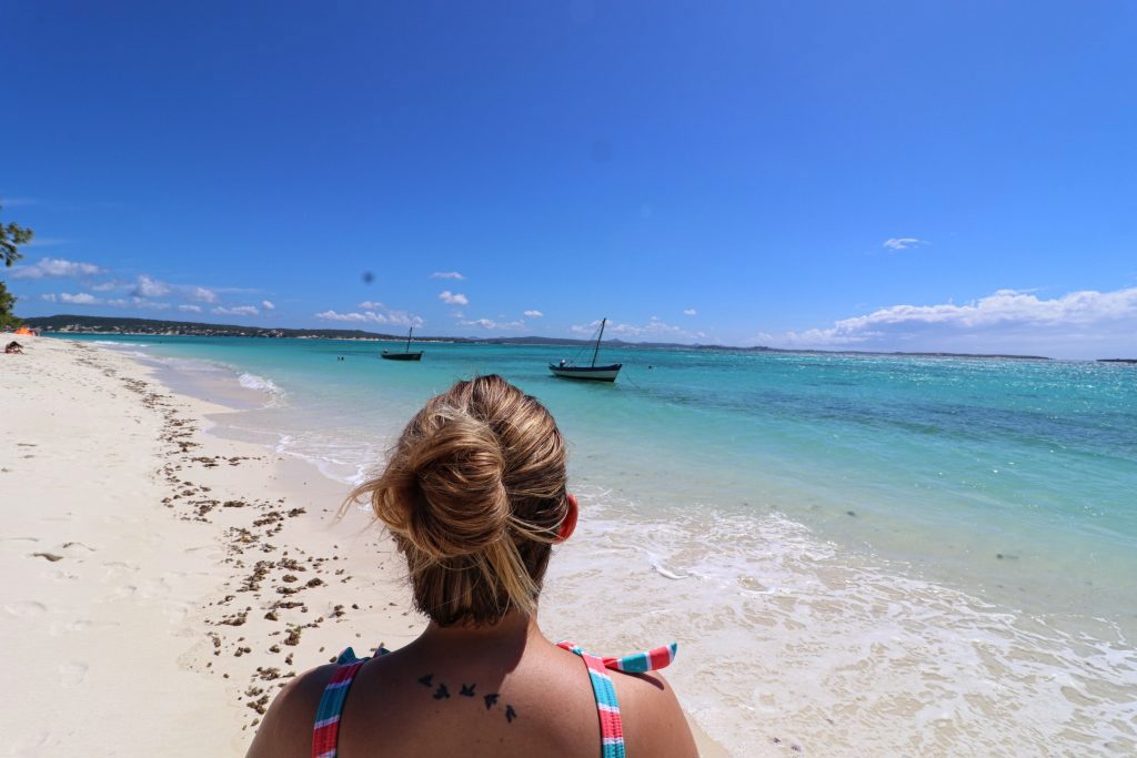 A woman looks at the stunning emerald sea