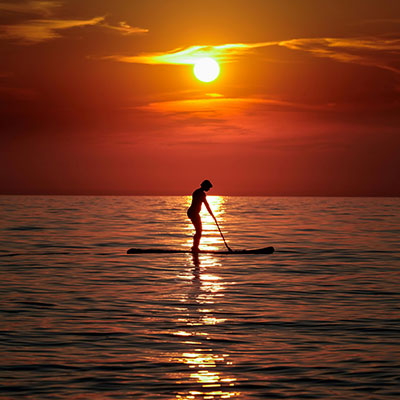 A paddleboarder at sunset on the ocean